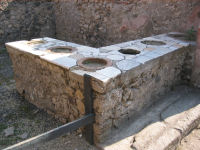 The mouths of various earthenware containers in the counter at VII.1.38-39, Pompeii.