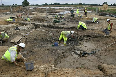 Prehistoric and Roman waterhole in the course of excavation (foreground) with associated complex of intercutting. linear landscape divisions beside it (left). ©YAT