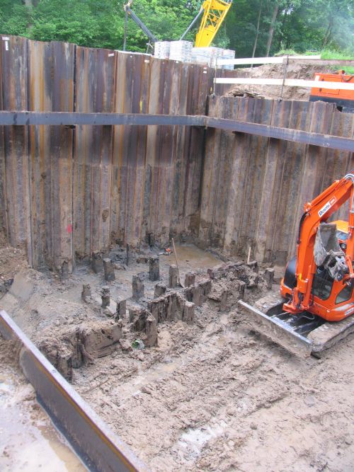 Archaeological remnants of a wooden grate, next to a digger