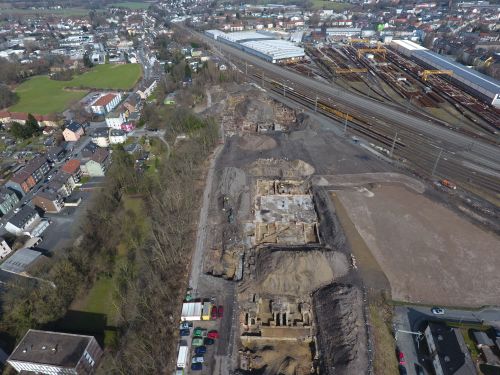 an aerial view of an archaeological trench next to train tracks and a housing estate