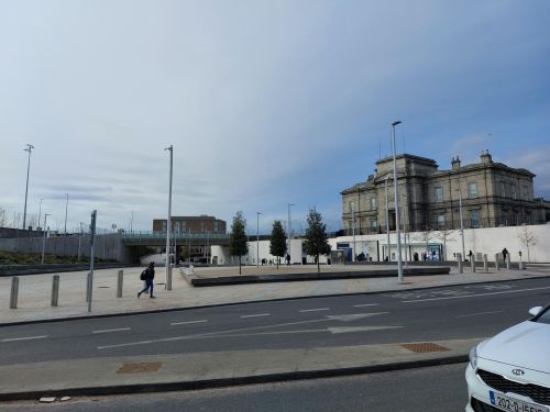 a road with buildings and a bridge in the background