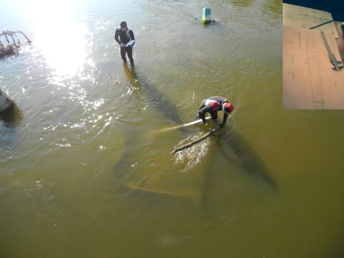 shipwreck in shallow water and paper diagrams in top right